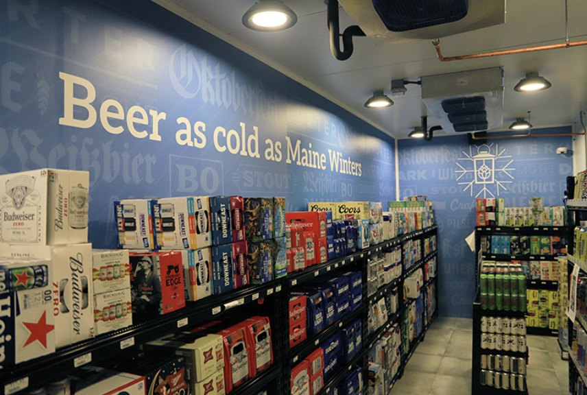 Inside a stocked liquor-store beer cave with glass merchandising doors